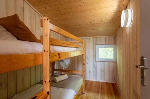 Chambre avec lit superposé en bois à La Loge Du Bassin, Lège-Cap-Ferret, draps blancs et vue sur le jardin