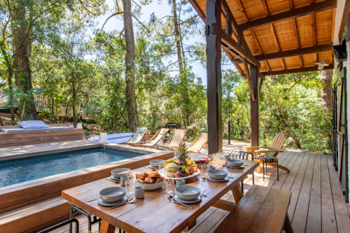 Terrasse piscine luxueuse à La Loge Du Bassin avec coin repas, chaises longues et vue sur la forêt à Lège-Cap-Ferret