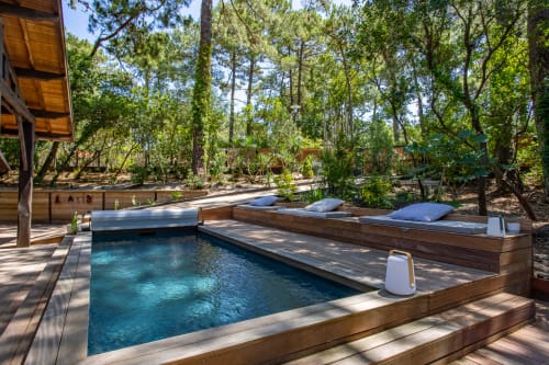 Piscine chauffée entourée de transats dans une forêt de pins à la villa La Loge Du Bassin à Lège-Cap-Ferret