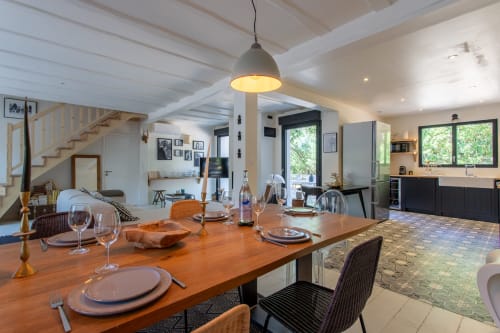 Salle à manger moderne avec table en bois à la villa La Loge Du Bassin à Lège-Cap-Ferret, éclairage suspendu noir et