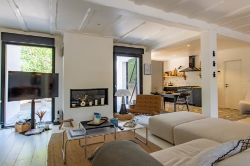 Salon-cuisine contemporain ouvert de la villa La Loge Du Bassin, avec coin séjour confortable, cheminée et salle à manger