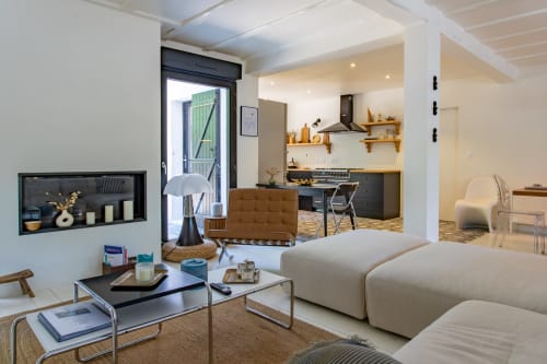Séjour ouvert et contemporain à la villa La Loge Du Bassin avec canapé beige, cuisine, salle à manger et niches noires