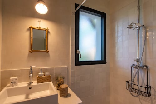 Salle de bain moderne de la villa La Loge Du Bassin avec lavabo, miroir en laiton, douche et équipements à Lège-Cap-Ferret