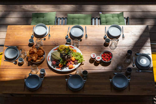 Espace de repas en plein air à la villa La Loge Du Bassin avec légumes frais et pains sur table en bois, couverts pour six personnes