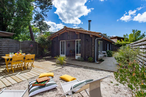 Villa aux boiseries sombres, mobilier de jardin jaune et transats à La Loge Du Bassin, Andernos-les-Bains