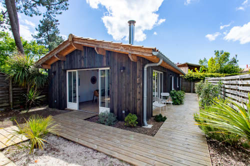 Villa La Palombière en bois sombre à La Loge Du Bassin à Andernos-les-Bains avec terrasse, vue sur jardin et plantes tropicales