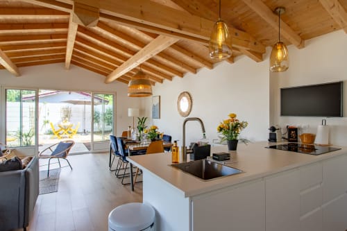 Cuisine ouverte et séjour moderne de la villa La Palombière à La Loge Du Bassin, Andernos-les-Bains, avec poutres en bois