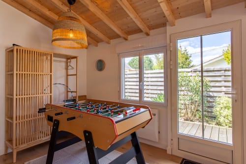 Table de baby-foot dans la salle de jeux lumineuse aux poutres apparentes de la villa La Loge Du Bassin, Andernos-les-Bains
