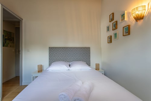 Chambre lumineuse à la villa La Palombière à Andernos-les-Bains avec literie blanche, tête de lit motifs et décoration côtière