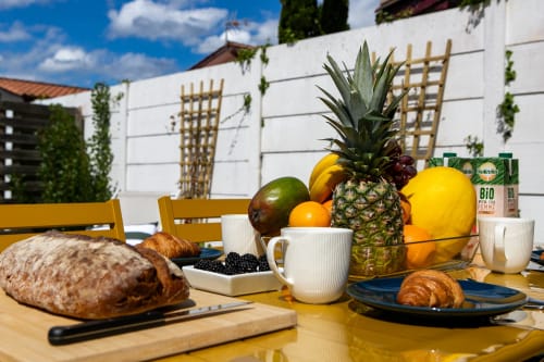 Petit-déjeuner en plein air à la villa La Palombière avec ananas frais, fruits, croissants et café à Andernos-les-Bains