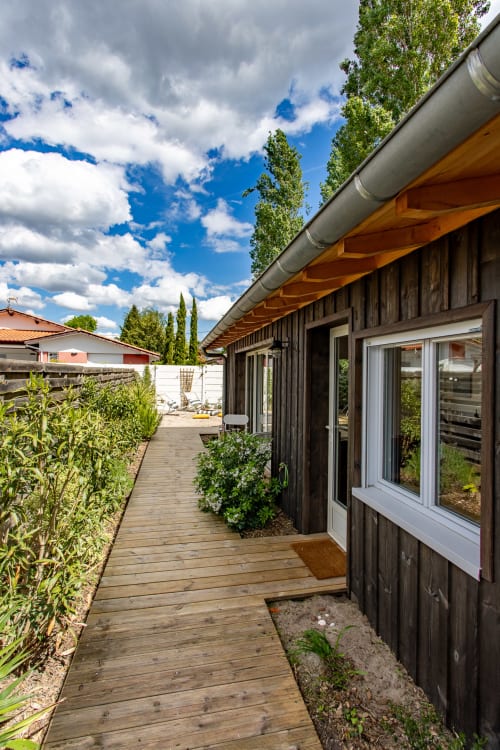 Villa La Palombière à La Loge du Bassin, Andernos-les-Bains : terrasse en bois aux finitions sombres, fenêtres blanches