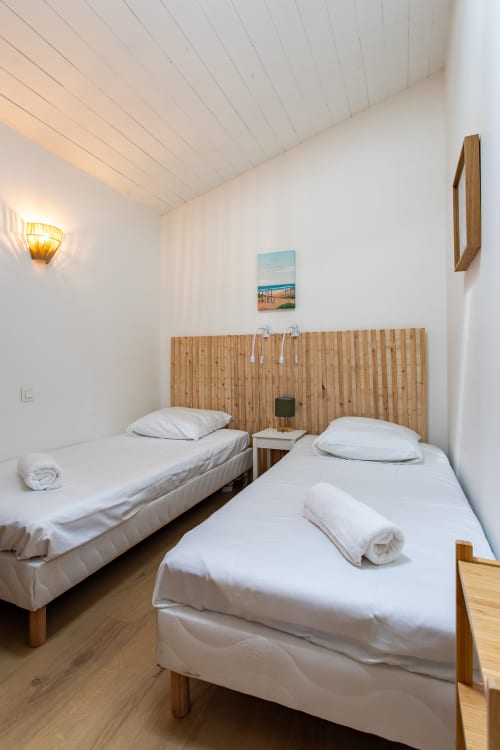 Lits jumeaux aux draps blancs dans une chambre lumineuse de la villa La Loge Du Bassin, Andernos-les-Bains
