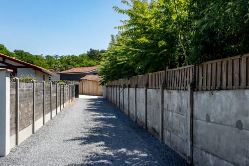 Allée de gravier entre murs en béton menant à la Villa la Parenthese à La Loge Du Bassin, Andernos-les-Bains