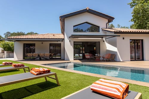 Vue sur la piscine de la Villa la Parenthèse avec bains de soleil, architecture moderne, piscine chauffée et salle à manger extérieure à Andernos-les-Bains