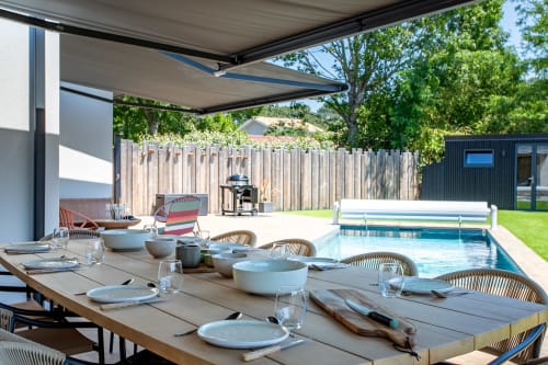Espace repas extérieur à Villa la Parenthese avec piscine chauffée, pergola moderne et jardin aménagé à Andernos-les-Bains