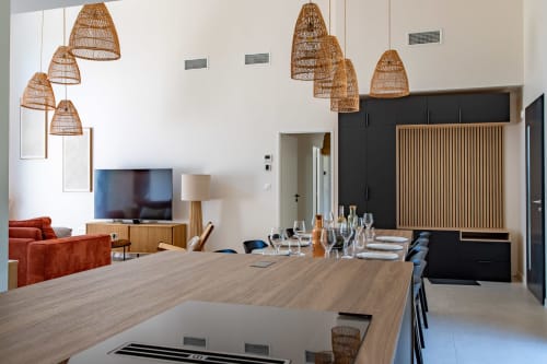Salle à manger de villa moderne avec luminaires suspendus tressés, table en bois et séjour à La Loge Du Bassin
