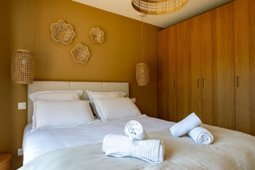 Chambre avec draps blancs, décor tissé et armoire en bois à la Villa la Parenthèse, La Loge Du Bassin, Andernos-les-Bains