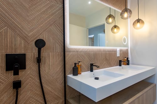 Salle de bain moderne à la Villa la Parenthèse avec vasque double, luminaires suspendus, carrelage chevron et accessoires noirs à La Loge Du