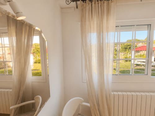 Luminoso dormitorio de cabaña con cortinas translúcidas, vistas al jardín, radiadores y mobiliario moderno en Holibai, Gondomar