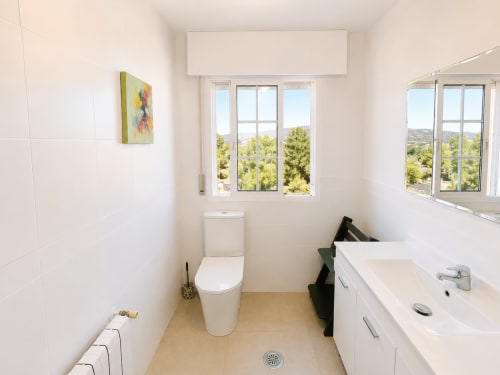 Baño moderno en la casa rural Nova Anduriña en Holibai, Gondomar con azulejos blancos, inodoro, lavabo y vistas al jardín