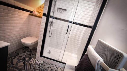 Salle de bain moderne au Clos du Buisson avec douche à l'italienne, carrelage blanc métro et sol à motifs dans la chambre Pivoines