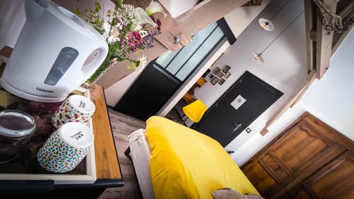 Chambre lumineuse au Clos du Buisson avec fauteuil jaune, fleurs fraîches et vue sur le jardin à Saint Aubin sur Gaillon