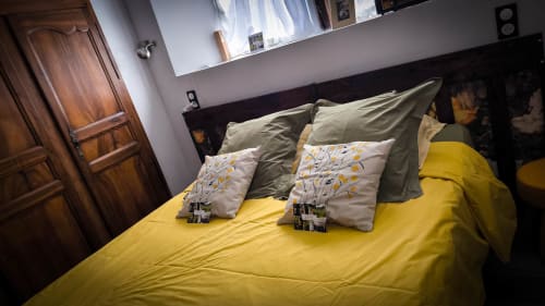 Chambre Pivoines au Clos du Buisson avec literie jaune, coussins décorés et vue sur le jardin