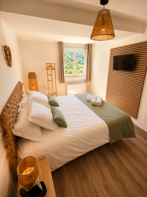Cozy studio bedroom in Sisteron with mountain views, wooden furnishings, and modern amenities including TV and kitchenette