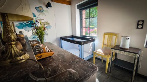 Spacieuse chambre double au Clos du Buisson avec vue sur jardin, décoration murale florale, équipements modernes, chaises jaunes et espace de jeu