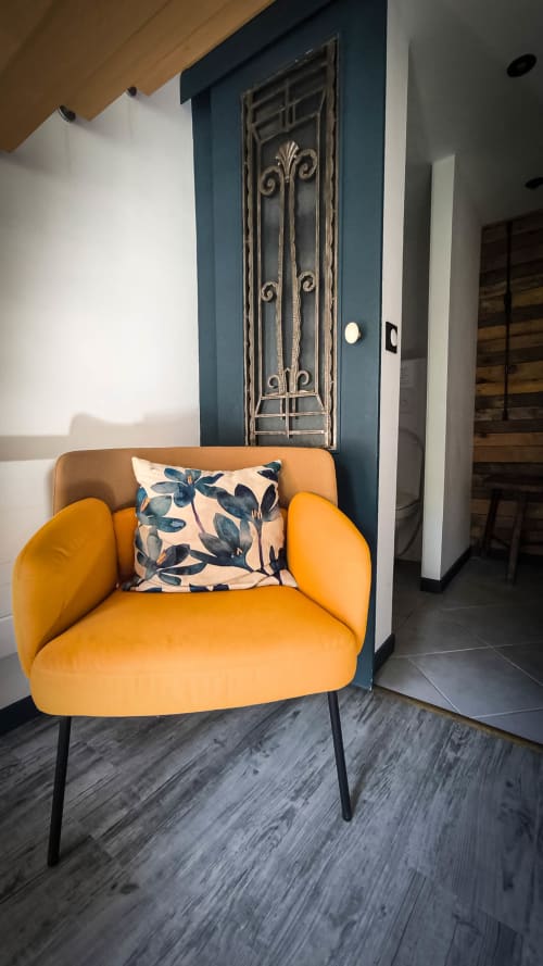 Fauteuil orange vif avec coussin à motifs dans la chambre du Clos du Buisson, Saint Aubin sur Gaillon