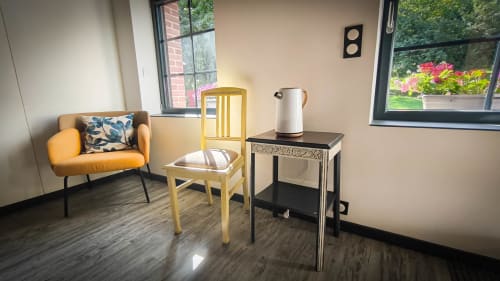 Séjour lumineux dans la chambre Clématites au B&B Le Clos du Buisson avec fauteuil jaune, causeuse orange et vue sur le jardin