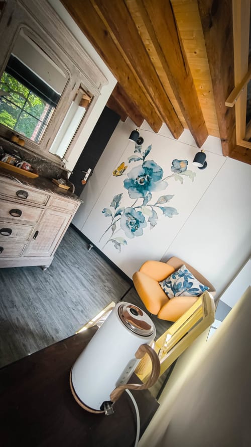 Chambre double confortable au Clos du Buisson avec poutres apparentes, décoration murale bleue à fleurs, fauteuil orange et vue sur jardin