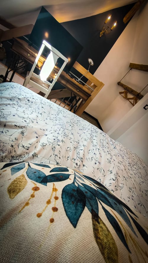 Chambre double Clématites au Clos du Buisson avec literie fleurie, vue jardin, TV et équipements modernes