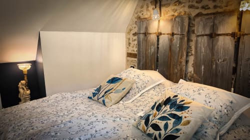 Chambre double avec literie à motifs et coussins bleus au Clos du Buisson, dotée de volets en bois et