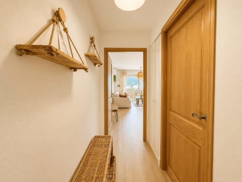 Couloir lumineux aux portes en bois et lumière naturelle dans un charmant appartement à L'Île-Rousse
