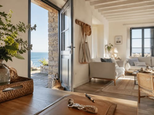 Bright coastal living room at ARLOÉ La Rochelle with ocean view, modern furniture, and stone accents
