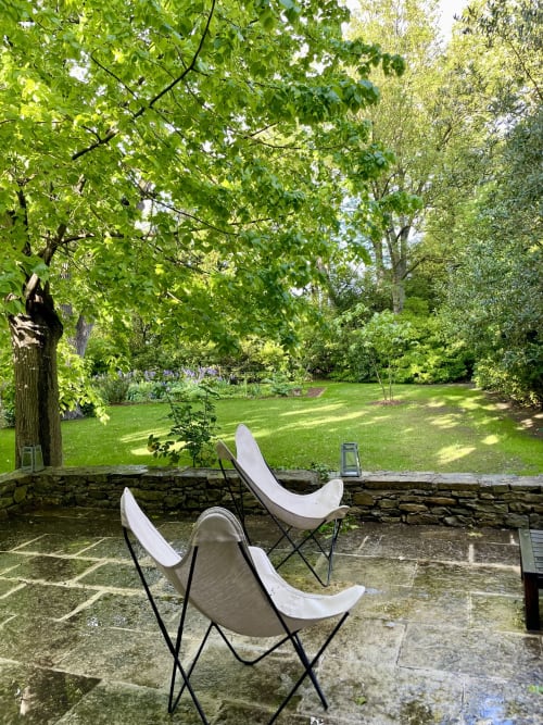 Chaises papillon sur terrasse en pierre offrant une vue sur le jardin luxuriant du Domaine de Montlaur B&B, Val-de-Dagne