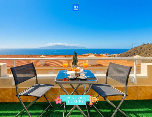 Luxury terrace at Elite Villas, Santiago del Teide, with sea view of Tenerife, outdoor dining setup, and coastal landscape