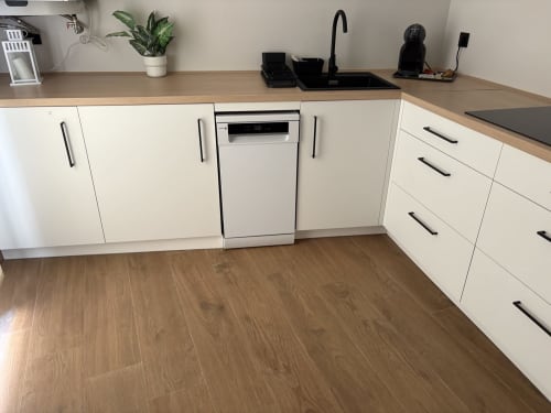 Cocina moderna y luminosa en Apartamentos YAKKA Yecla equipada con lavavajillas, fregadero, encimera de madera y suelo de tarima