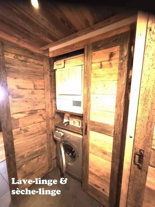 Buanderie compacte avec lave-linge et sèche-linge dans un chalet en bois à Zoppas Courchevel