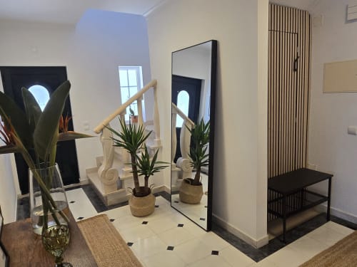 Modern entryway at Casa Forever Young villa in Sesimbra with mirror, plants, tiled floor, wooden staircase and black bench