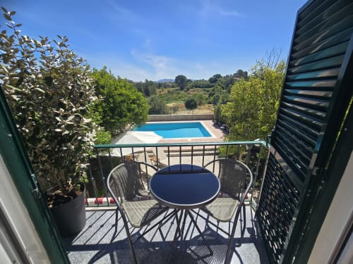Balcony terrace overlooking private pool and gardens at Casa Forever Young villa in Sesimbra