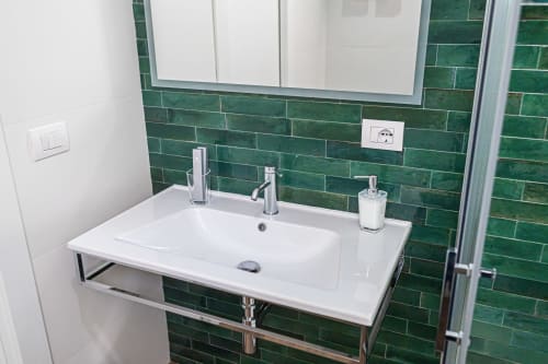 Bagno moderno dell'hotel Melo 48 a Bari con lavabo bianco, rivestimento in piastrelle verdi e specchio