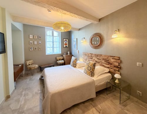 Elegantes Schlafzimmer im Hôtel La Suite in Villeneuve-lès-Avignon mit warmen Beigetönen, Holzkopfteil und zeitgenössischem Hängeleuchte