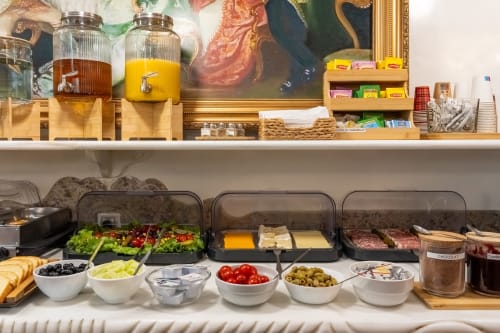 Buffet petit-déjeuner de l'Hôtel Royal Paris Ivry avec boissons, salades fraîches, fromages, charcuteries, olives et pain
