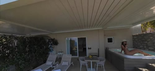 Private Rosaria apartment terrace at Villa D Alessandro in Anacapri with hot jacuzzi, sea views, lounge chairs, and covered
