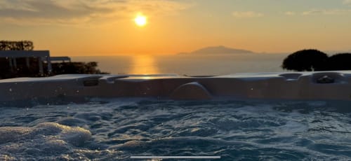 Sunset view over the Mediterranean Sea from a private jacuzzi at Villa D Alessandro in Anacapri, with Mount Vesuvius visible