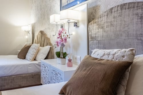 Hotel Royal Paris Ivry Triple Deluxe room with two beds, pink orchid flowers, and modern neutral décor in Ivry-sur-Seine