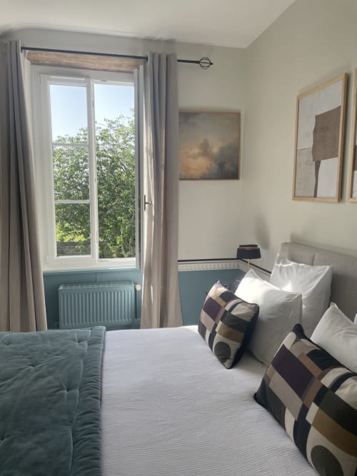Chambre lumineuse au domaine de Marculfo avec vue sur le jardin, lit avec oreillers, radiateur et portes-fenêtres