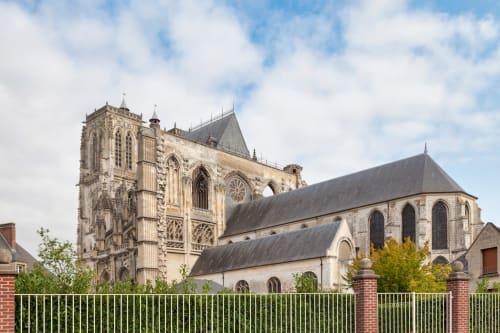 Architecture gothique de la cathédrale au Cardinal, Poix, France, avec sa façade en pierre sculptée et ses flèches élancées